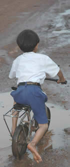 Laos (Savannakhet) : boy bicycle mud :  copyright Chris Smith csmith@csmith.info (photographer)